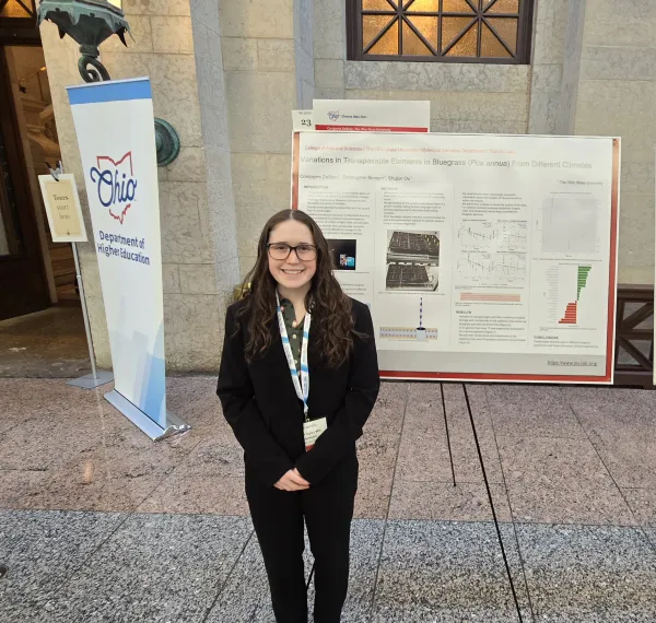 Corajayne in front of her poster presentation